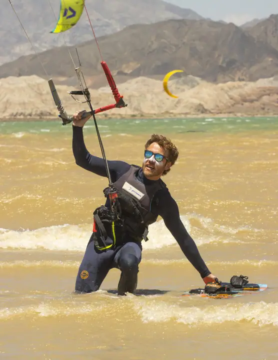 Kiter en el agua con el kite arriba durante el acompañamiento del instructor