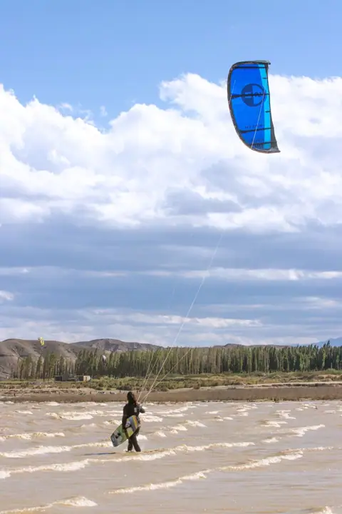 Kite azul sobre el embalse en una tarde de viento