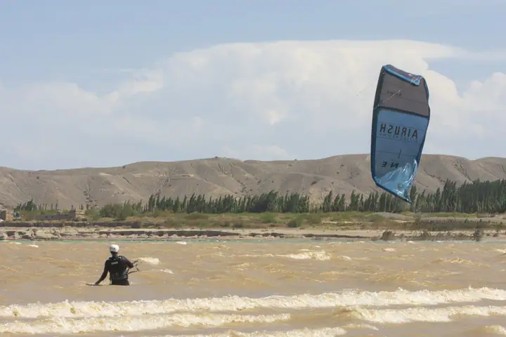 Kiter navegando el embalse de Cuesta del Viento con las montañas de fondo