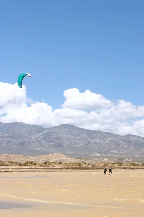 Kite en el aire sobre el agua poco profunda del embalse