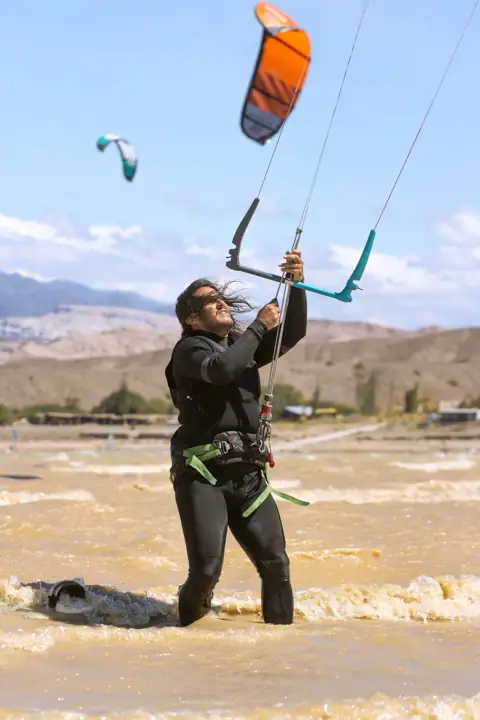 Alumno levantando el kite del agua durante la clase
