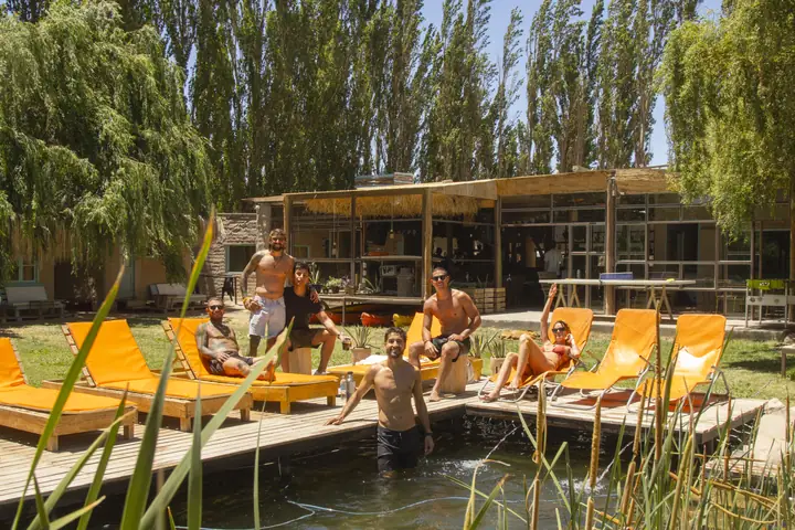 Grupo descansando en el deck de madera junto al agua después de navegar