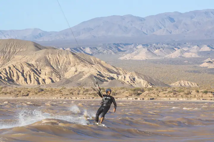 Kiter navegando con spray frente a las montañas de Rodeo