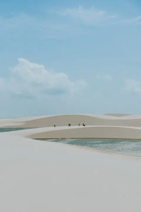 Laguna entre dunas de arena blanca bajo el cielo despejado