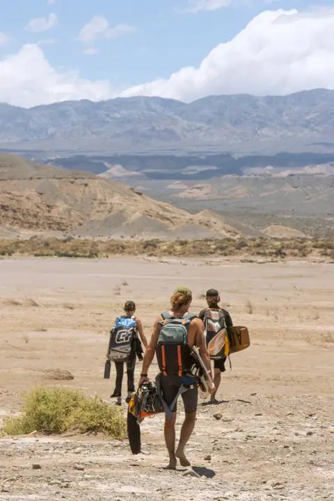 Caminando hacia el agua con los equipos al hombro