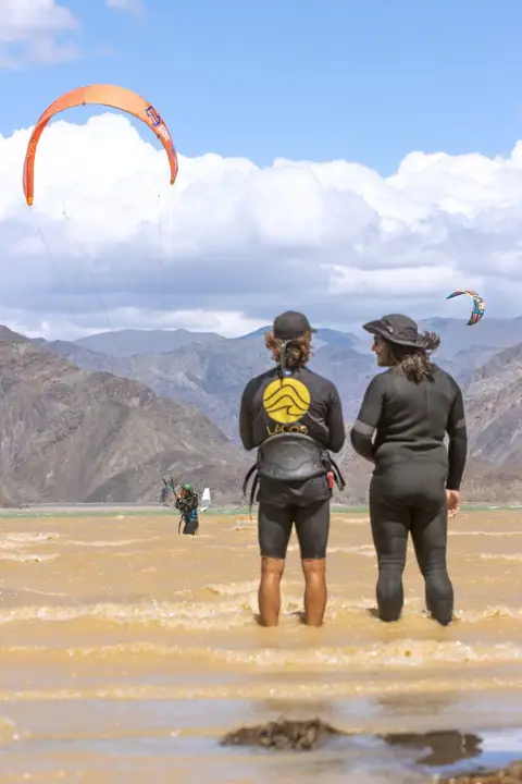 Instructora y alumna caminando hacia el agua